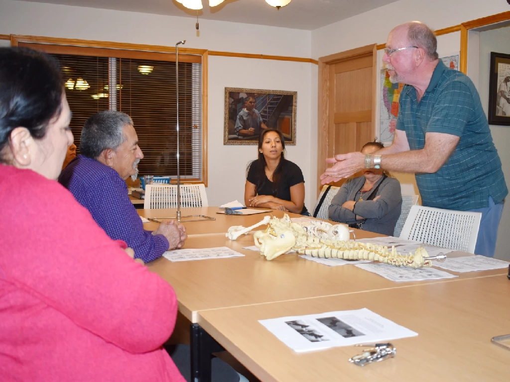 A health care professional provides education to a group of people at an office