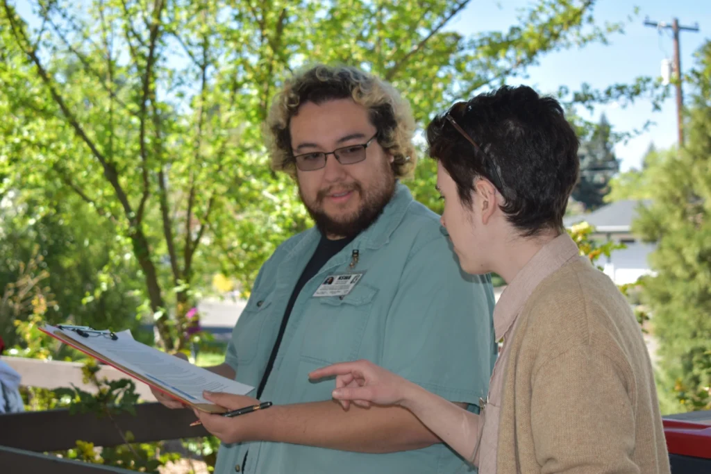 Two volunteers discuss the plan of a spring event at the location of the event